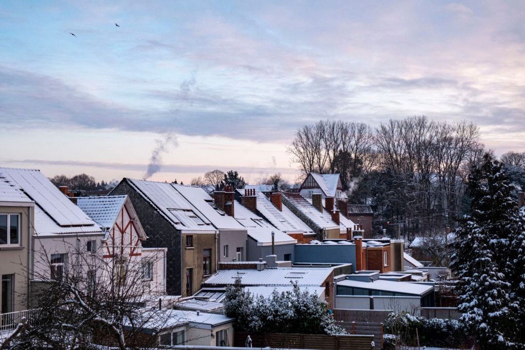 Snow-covered houses under a dawn sky.