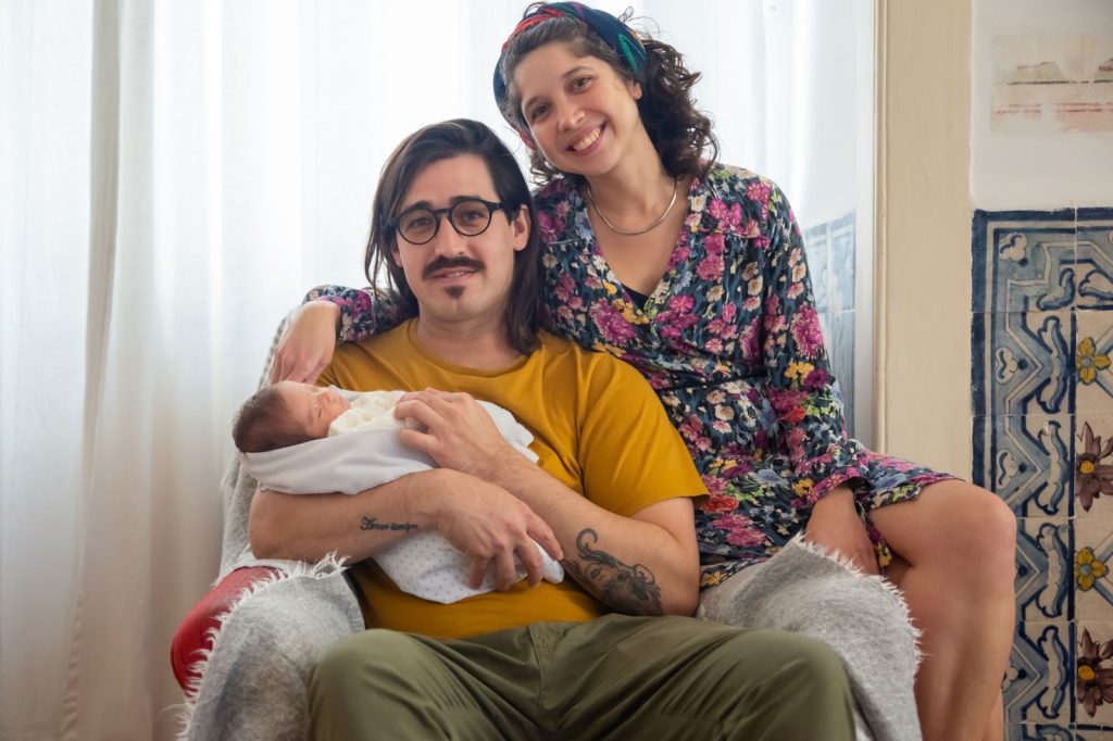 A happy mother and father at home with their newborn.