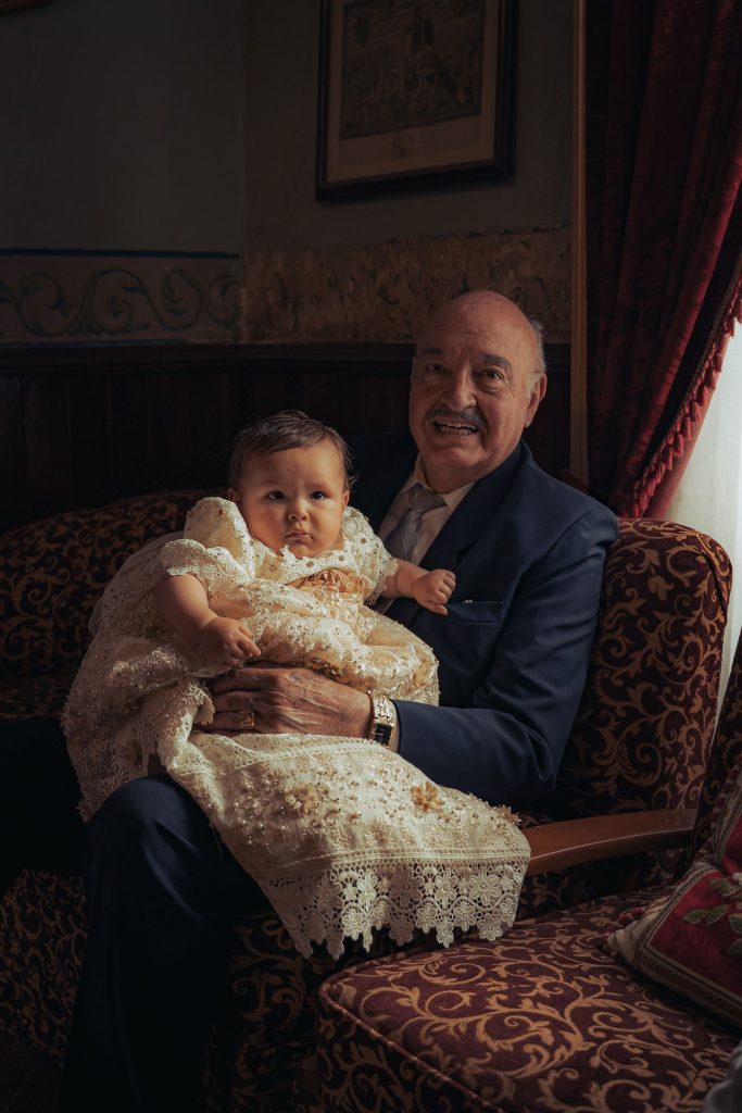 A grandfather holding a baby.