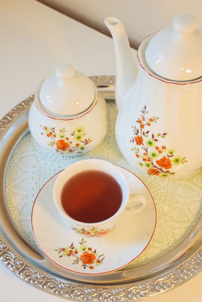 A flowered china tea set on a silver tray.