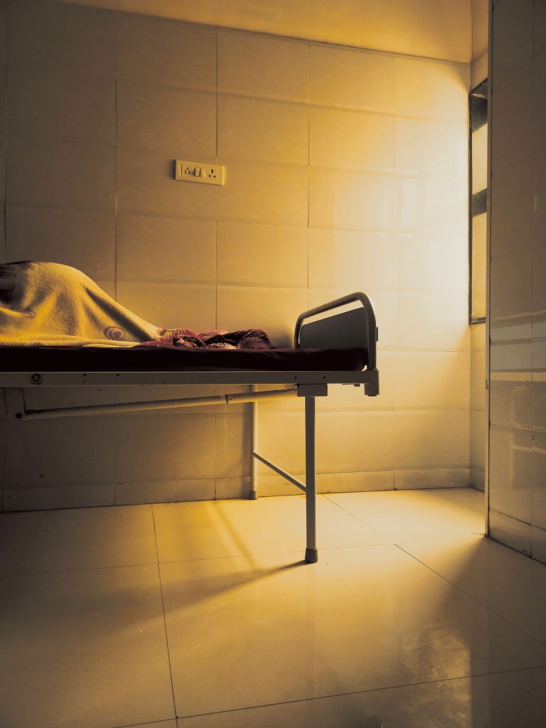 A quiet hospital room with a bed in warm light.