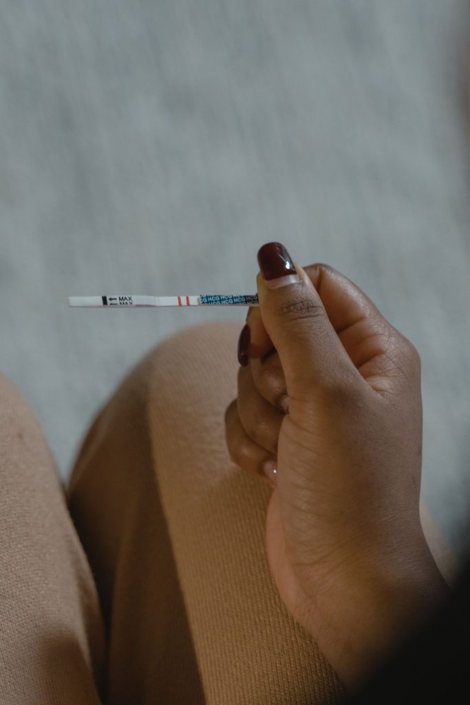 A hand holding a home pregnancy test.